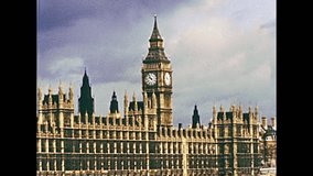 Big Ben clock tower and Westminster Palace in London, Houses of Parliament by the river Thames. Historic restored footage on 1970s in England United Kingdom. 