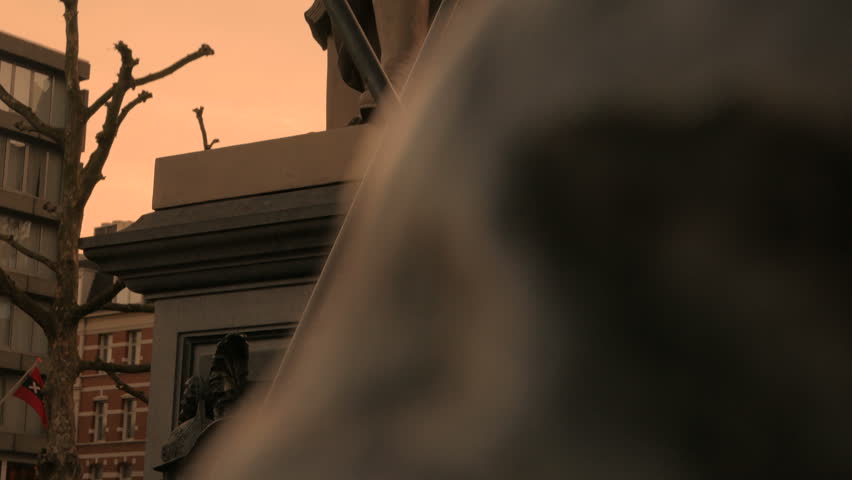 A tilting shot revealing the statue of Rembrandt in the center of Amsterdam, The Netherlands