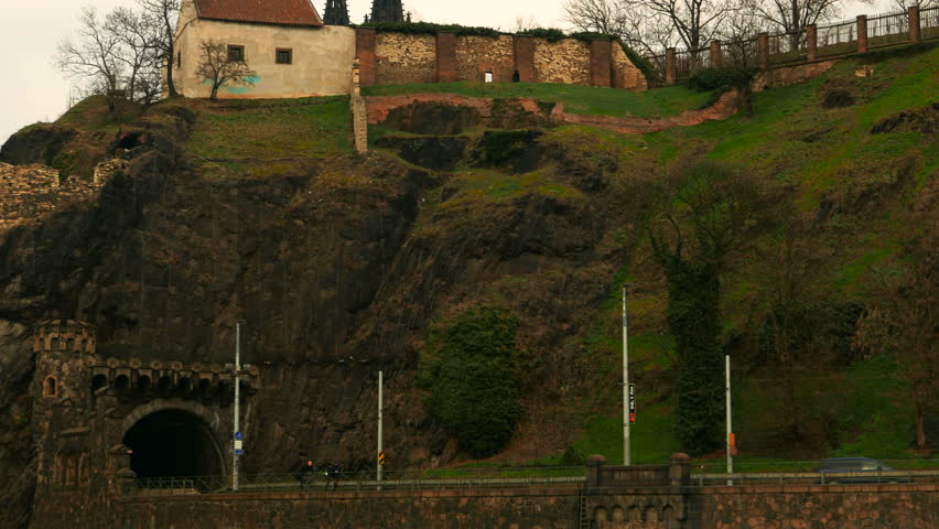 A medium telephoto showing traffic crossing a Gothic sculpted tunnel in Prague, Czech Republic - Czechia
