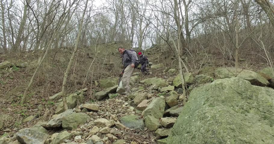 Man and woman tourists go down complex path among rocks in canyon