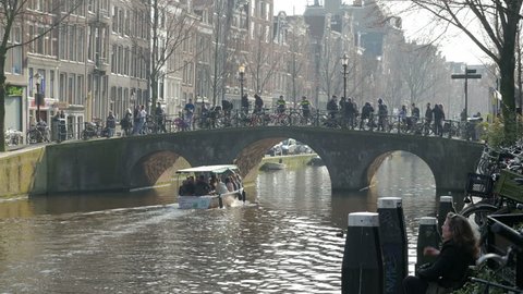 Amsterdam, Netherlands - March 2017. Visitors passing over canal bridge within the Red Light District, Oudezijds Voorburgwal Amsterdam's Red Light District, Amsterdam, Netherlands, Europe