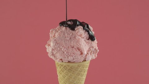 Strawberry ice cream with cone on pink background