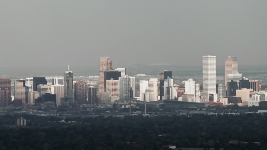 Sunlight shines on Denver, Colorado on a hazy winter day. HD 1080p aerial pan