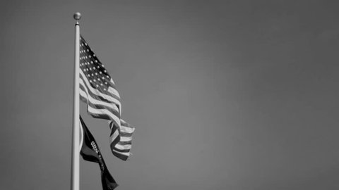 An American flag flowing with a Vietnam POW MIA Flag - Black and White Version