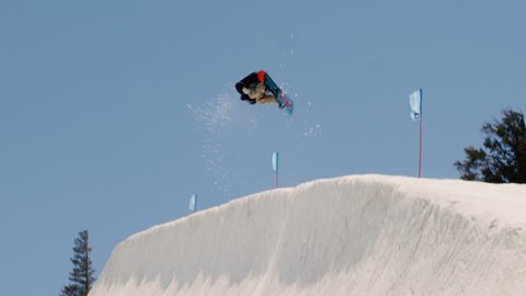 Snowboarder Gets Big Air and Spins in Halfpipe