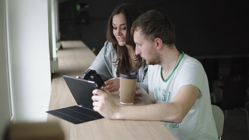 Work meeting in photo agency. Client and photographer discuss the order and watch the results of work. Shot in 4k
