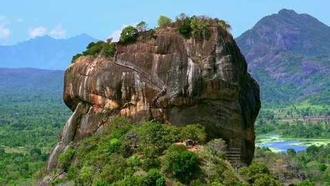 Tourists visiting famous Lion Rock fortress with ancient gardens world heritage in Sri Lanka. Aerial view on amazing landscape near Sigiriya. Zooming video