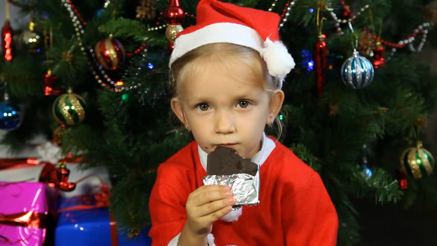 child eating chocolate near christmas tree Stock Footage Video (100% ...