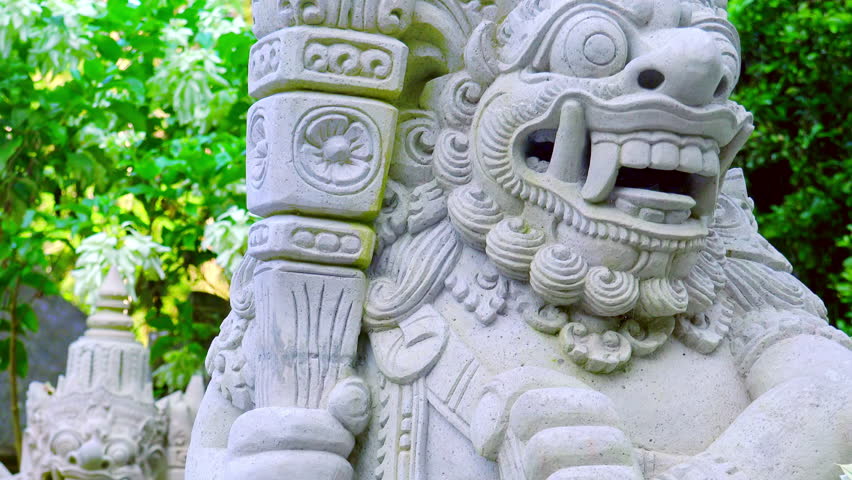 Highly detailed white rock statues of Barong Lion Guard, mysterious animalistic creature from Balinese mythology in Gunung Kawi Temple Complex, Bali, Indonesia. Front view, camera slowly zooms out.