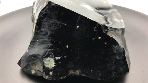 Rotating close up of big piece of black Obsidian, a natural volcanic glass.