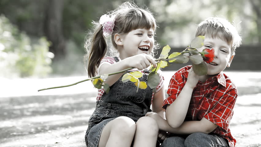 Two child speaking and boy present flower