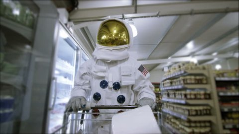 4K Off duty astronaut walking through supermarket, shopping for groceries