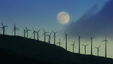 Night shot of wind turbines producing clean alternative energy in silhouette