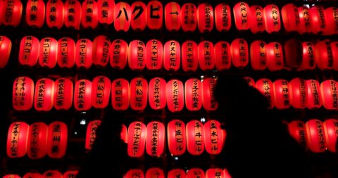 Silhouette of people walking in the night with red lanterns background. Tokyo, Japan.