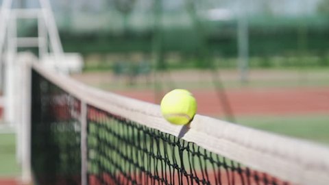 close up of tennis ball hitting the net slow motion