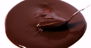 Video footage of liquid chocolate stirred with a spoon. Professional shot in 4K resolution