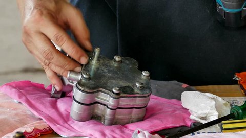 Mechanic repairing spare parts of engine car in service station.