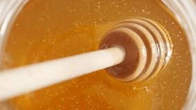 Top view of wooden honey used in jar slow-mo 1920X1080 HD footage -  Slow motion of golden sweet food substance and useful utensil 1080p FullHD video