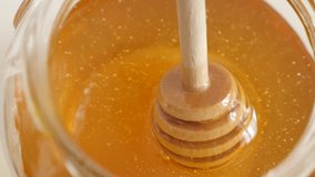 Wooden honey dipper used in jar slow-mo 1920X1080 HD footage -  Slow motion of golden sweet food substance and useful utensil 1080p FullHD video