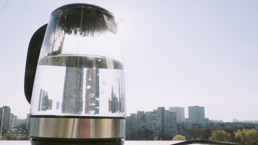 SLOW MOTION: Boiling kettle on the background of sunrise, 240 fps.