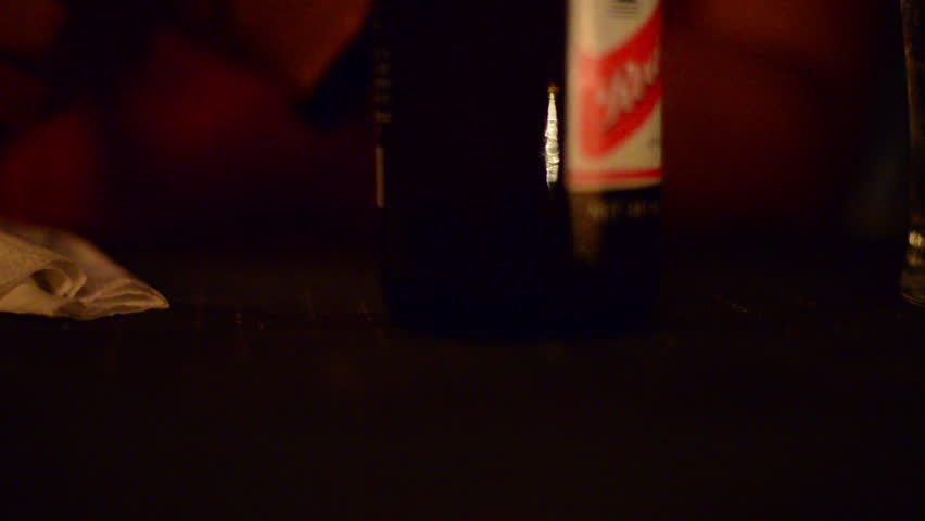 Close up, beer bottle by candlelight
