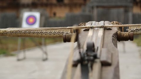 Old wooden arbalest and targets at background. Ancient ballista. Crossbow is aimed at a target