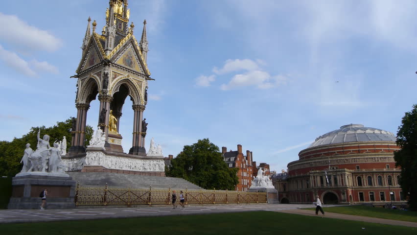 The Albert Memorial with the Royal Albert Hall in the background. Evening shot, low sun, blue sky with a few clouds.