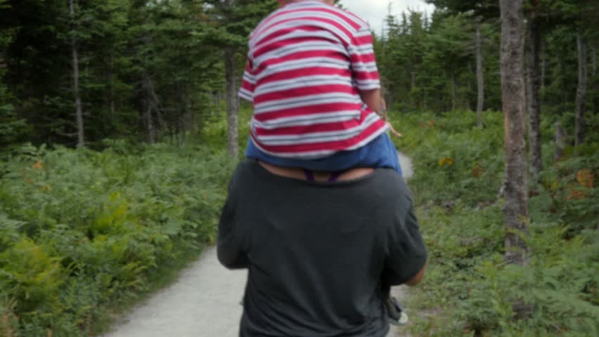A family hikes on the skyline trail in Cape Breton Nova Scotia Canada at the famous Cabot Trail