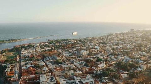 Aerial view sunset city Santo Domingo. Monuments and squares of Dominican Republic. City and Caribbean sea view from above. Top view city center coastline. Sea shore landscape. Capital city by ocean