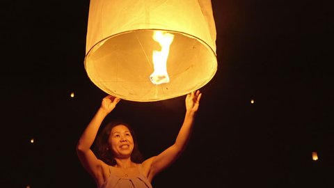 Asian woman releasing a sky lantern to wish for good luck. Adlı Stok Video