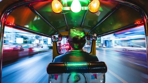 Bangkok, Thailand - March 21: Tuk tuk ride motion time lapse at night in Bangkok, Thailand. Tuk-tuks are a popular means of transportation in Southeast Asia.