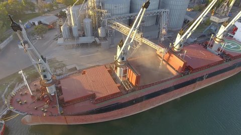 Aerial view of big grain elevators on the sea. Loading of grain on a ship. Port. Cargo ship