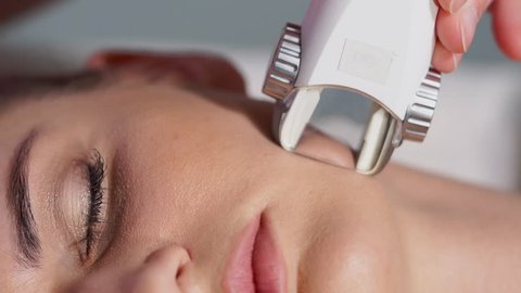 Close up woman getting facial LPG vacuum massage in beauty salon. Doctor using professional equipment for facial hardware cosmetology.