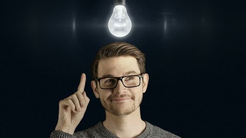 Clever creative man think gets an idea, which lights up a symbolic lamp over his head on dark background