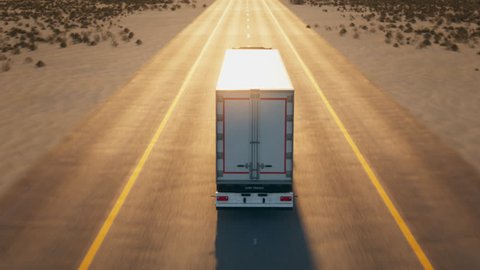 Truck Driving On Asphalt Road At Desert Landscape