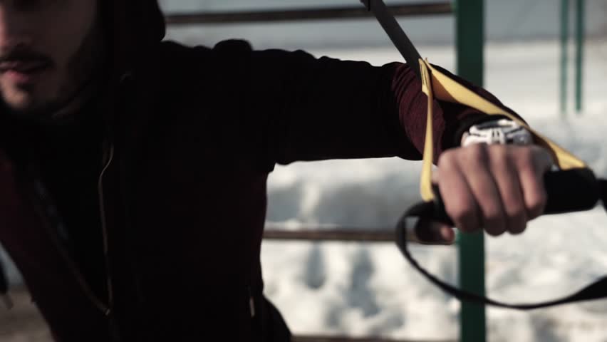 Male caucasian or middle eadtern adult working out with fitness straps