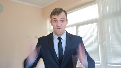 Angry businessman in office screaming at camera close-up