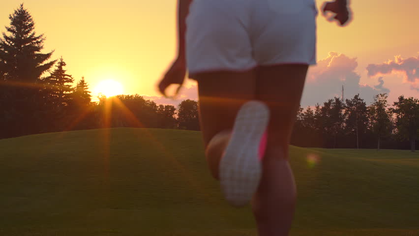 African woman jogging in park. girl running sunset. Young woman running back. Back view of woman running hill at sunrise