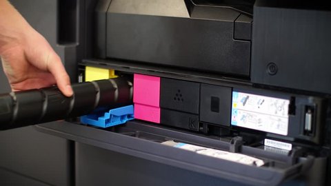 Man puts toner in the printer YCMK
