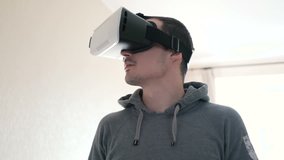 Man wearing virtual reality headset at living room.