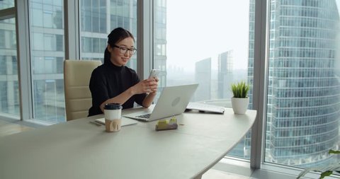 young business Asian girl texting on smartphone in office