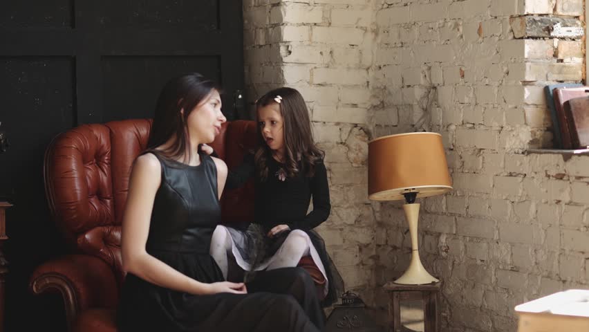 Mother and daughter hugging and playing together. Pretty little girl on beautiful woman