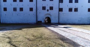 Turun linna, Cinema 4k rising tilt aerial of Turku castle, with a finnish flag waving in the wind, on a sunny spring day, in Abo, Finland