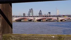 Office blocks in the City of London framed by part of a jetty. Camera move in the clip.