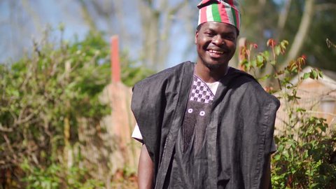 Portrait of a happy handsome Black man, wearing traditional African tribal clothing from Nigeria. Exploring culture tribe tradition and travel Africa. Summer holiday meeting locals