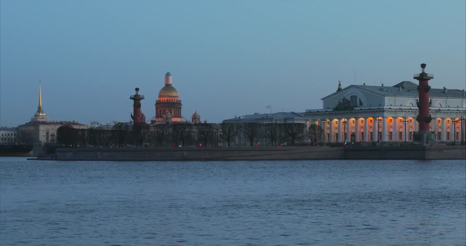 Russia, Saint-Petersburg, 30 March 2017:  The Vasilievskiy Island at sunset, Rostral Columns, Palace Bridge, water reflections, old stock exchange building, Isaac cathedral, night illumination