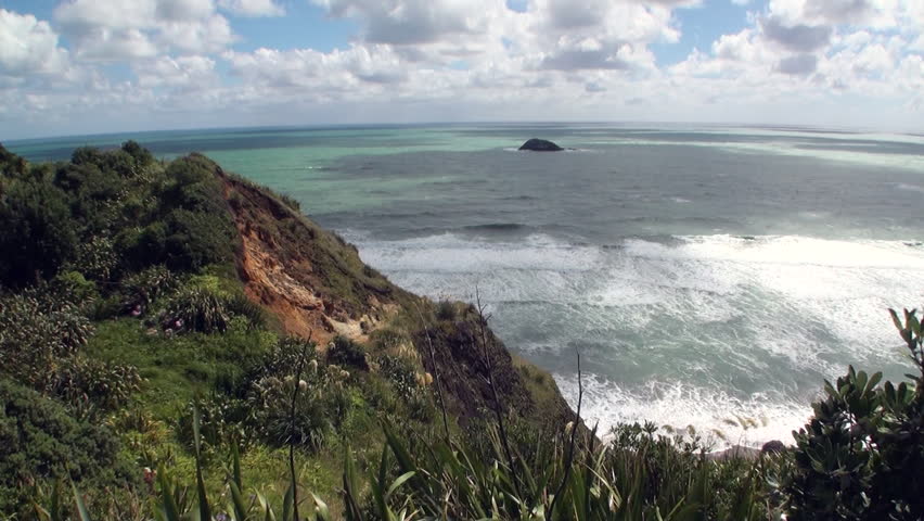 Seascape on background of horizon, clouds in sky and rocks New Zealand. Beautiful background of amazing nature. Travel and tourism in the world of wildlife.