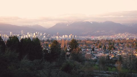 A Sunset Timelapse of Urban Downtown Vancouver's Cityscape from Queen Elizabeth Park Viewpoint with Mountains and Clouds as Backdrop