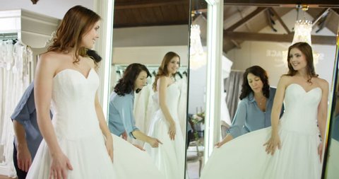 4k, Owner assisting young bride getting dressed in wedding gown. Slow motion. 库存视频