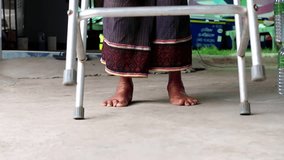 Elderly Asian woman taking steps with a walker,low angle. 
